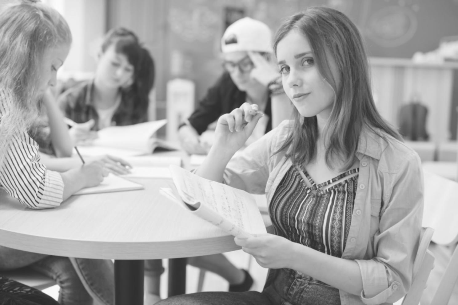 Student project team reviewing financial data and planning materials on desk
